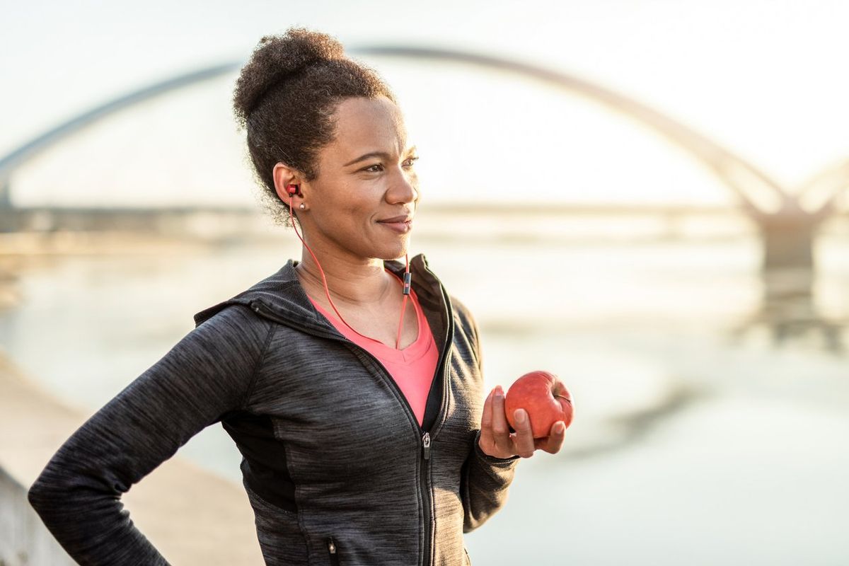 woman in exercise clothes holding an apple
