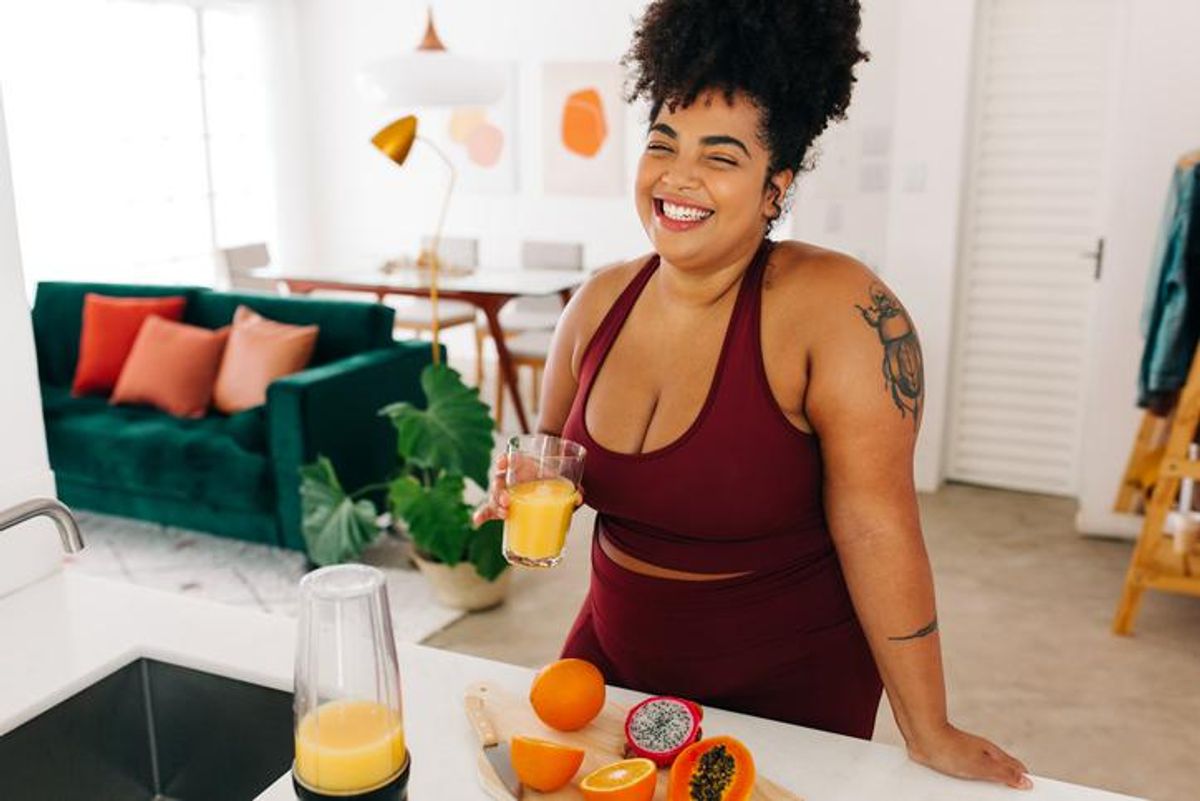 Woman in sportswear having fruit juice