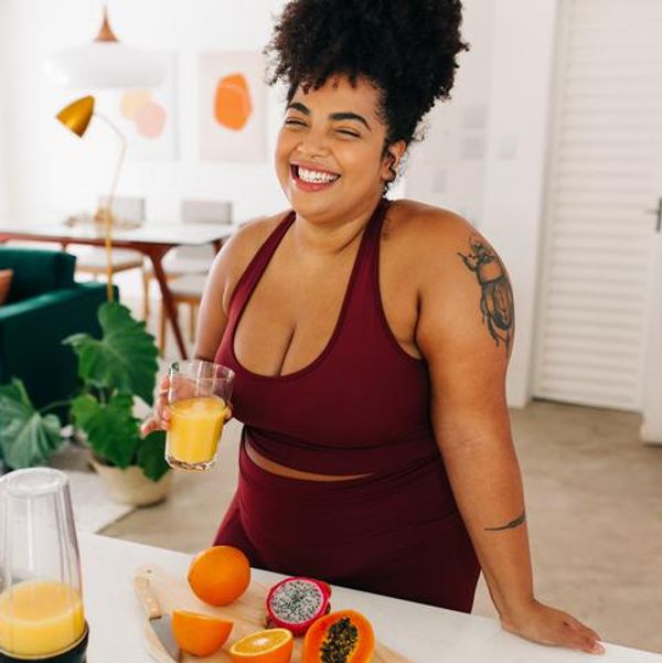 Woman in sportswear having fruit juice