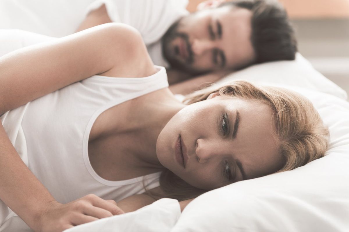 woman laying in bed, worrying about antidepressants affecting her sex drive