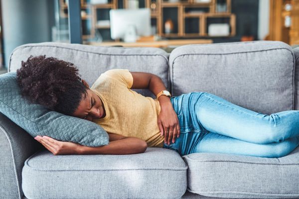 woman laying on the couch due to pain from Heavy Periods