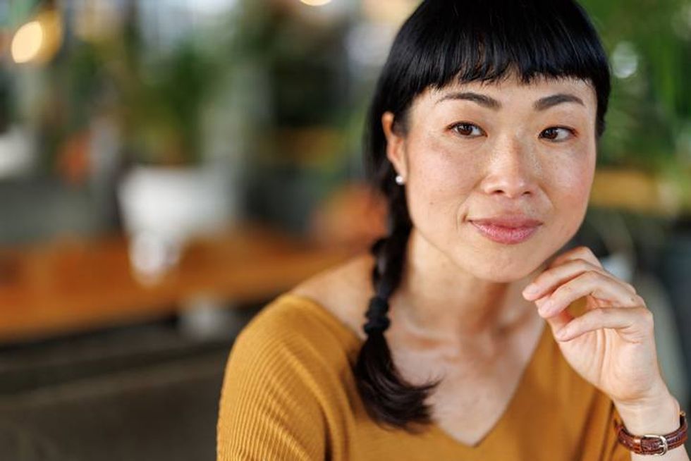 woman looking around thoughtfully at modern caf\u00e9