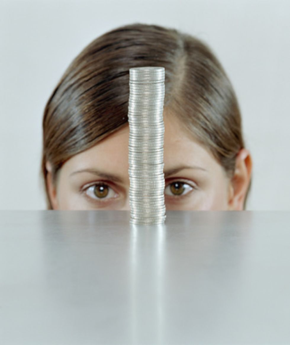 woman looking at a stack of coins