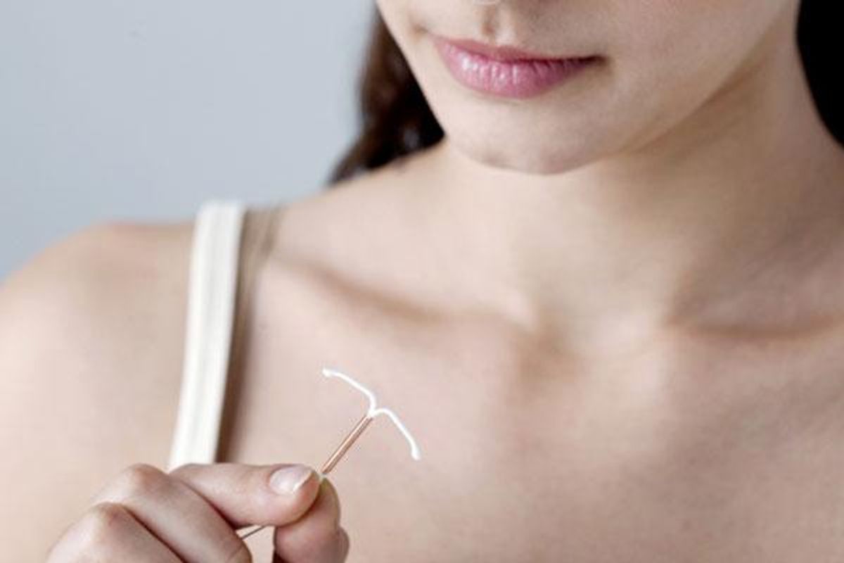 woman looking at an IUD