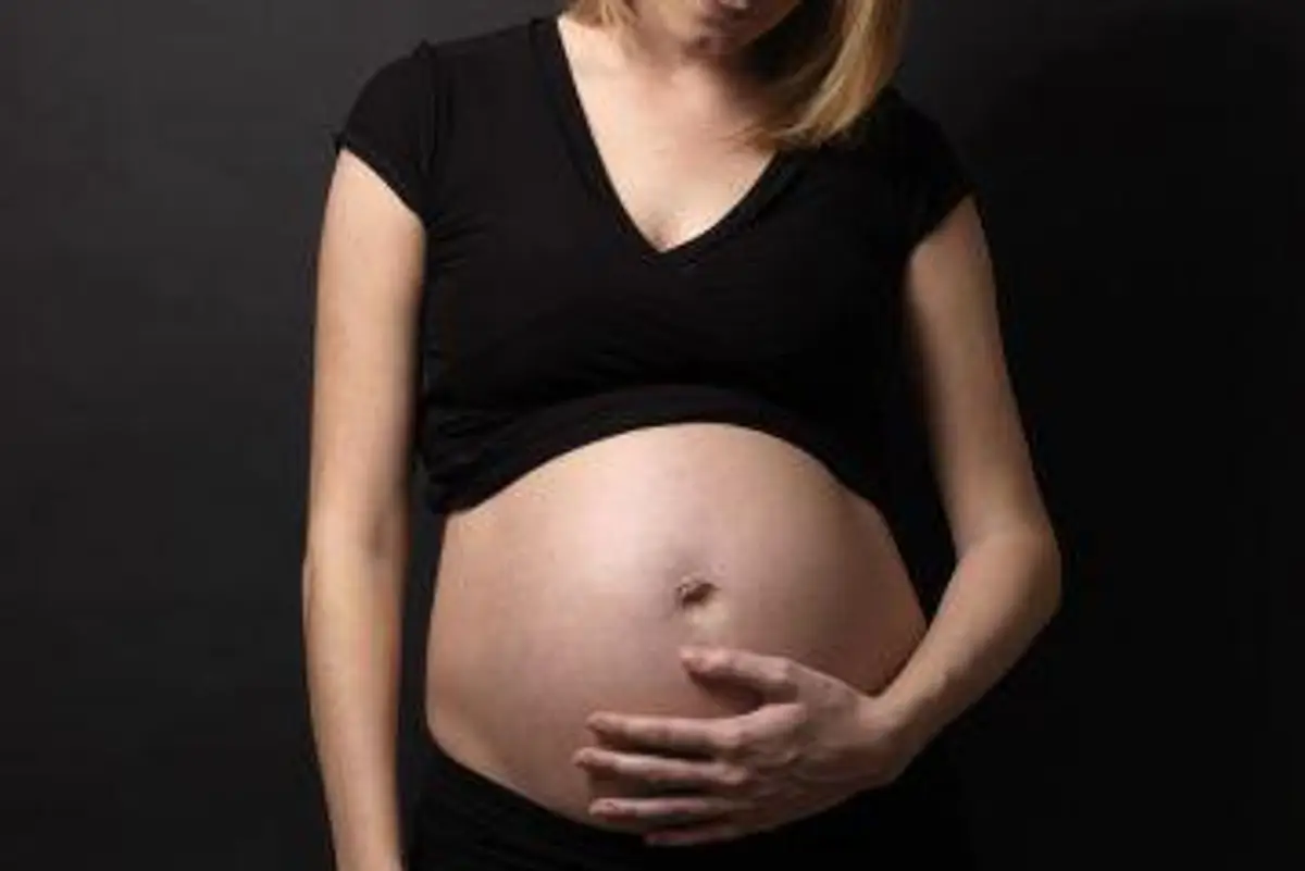 woman looking at her pregnant belly