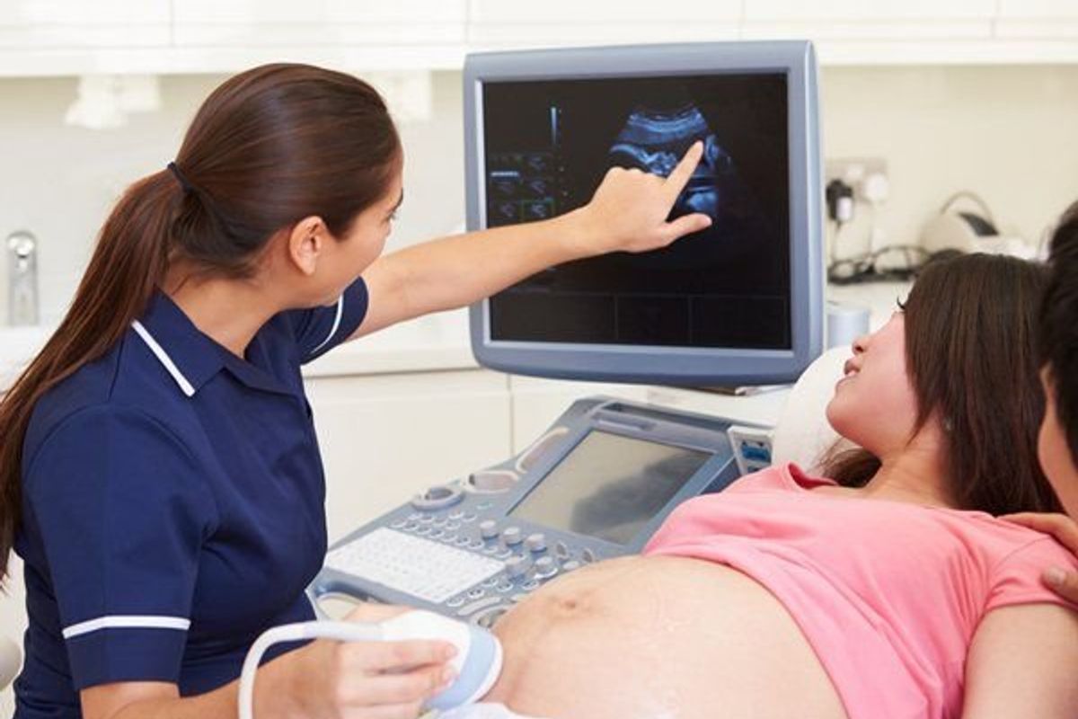 woman looking at ultrasound of her baby