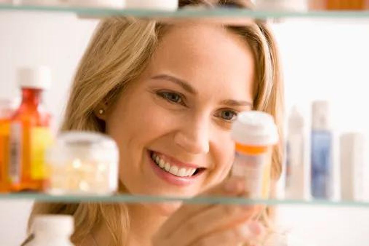 woman looking in her medicine cabinet