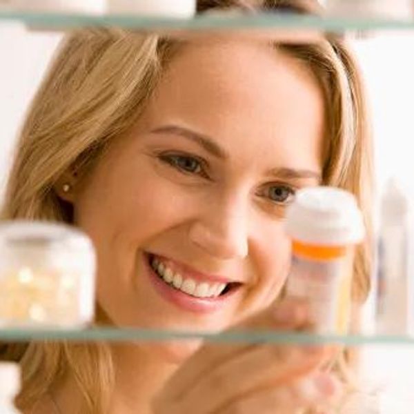 woman looking in her medicine cabinet