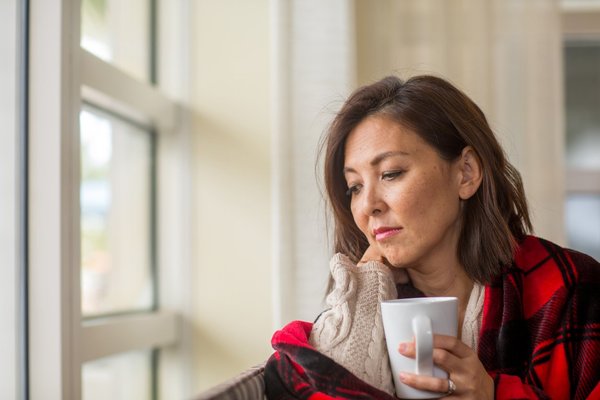 woman looking out the window feeling sad