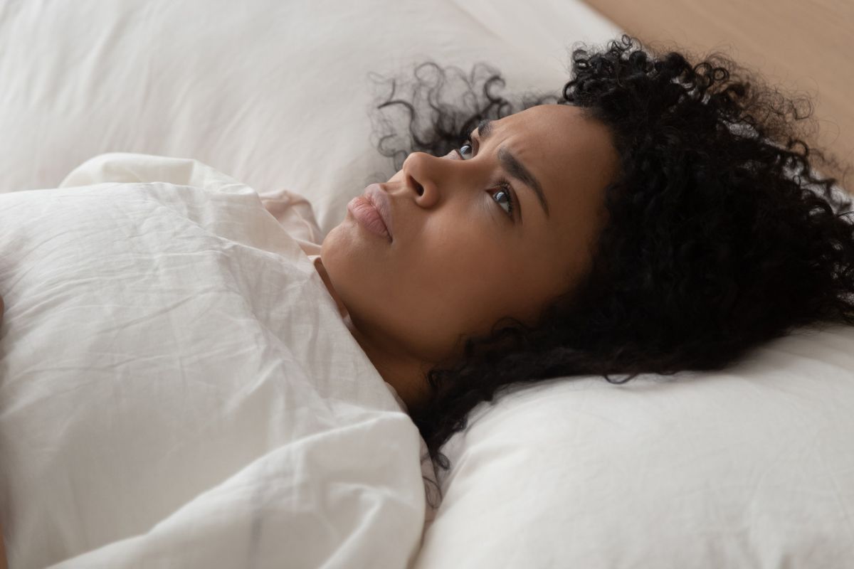 woman lying in bed having sleep disorder sleeping trouble looking at ceiling cannot fall asleep