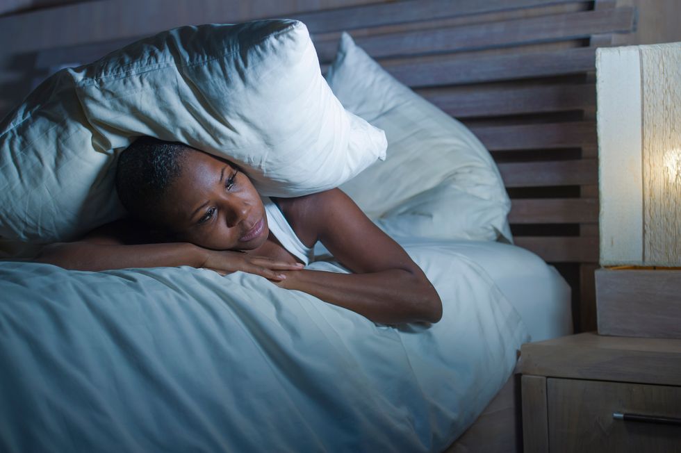 woman lying on bed upset trying to sleep suffering insomnia