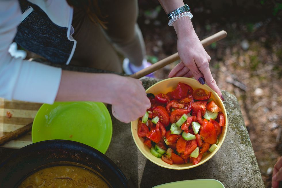 woman making cucumber tomato salad