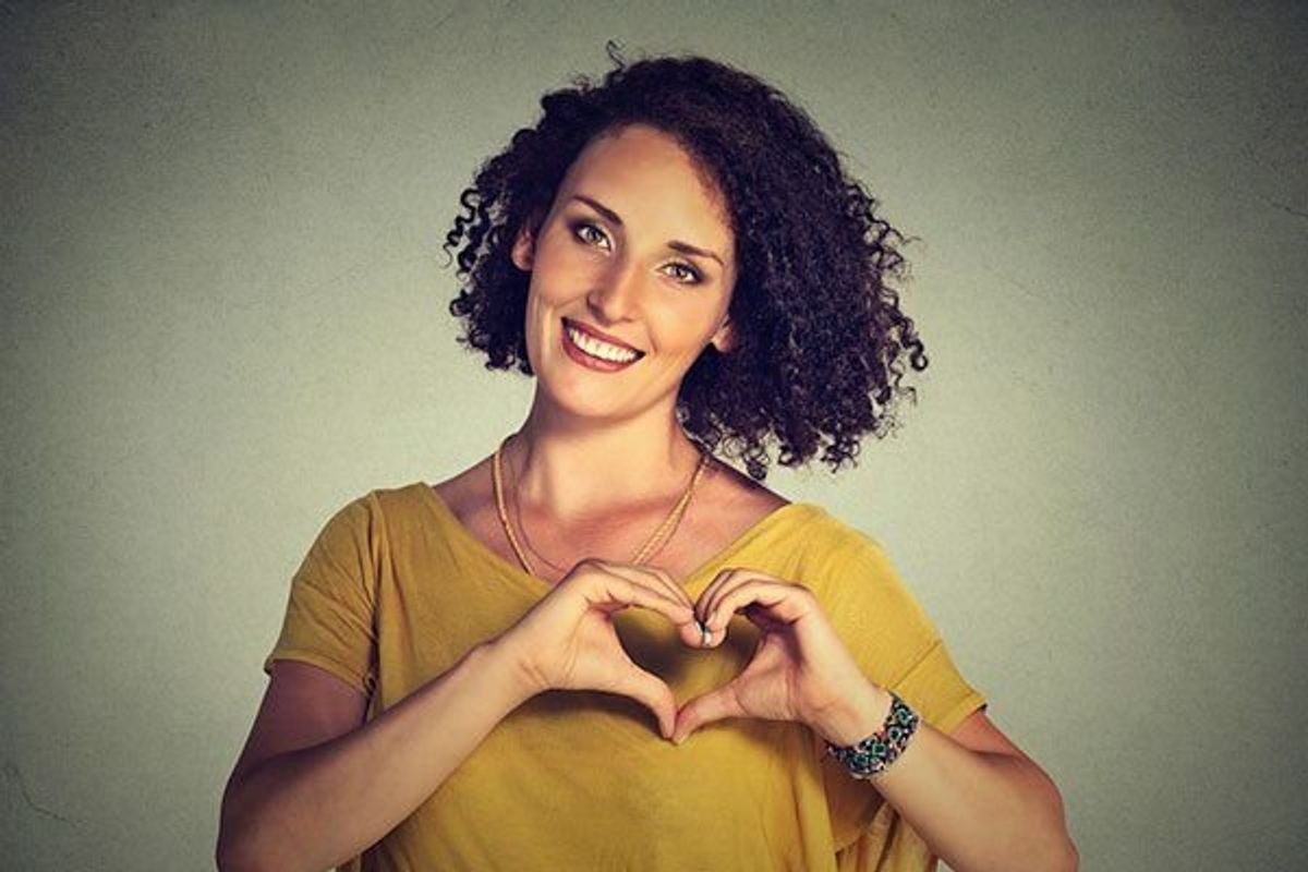 woman making the shape of a heart with her hands