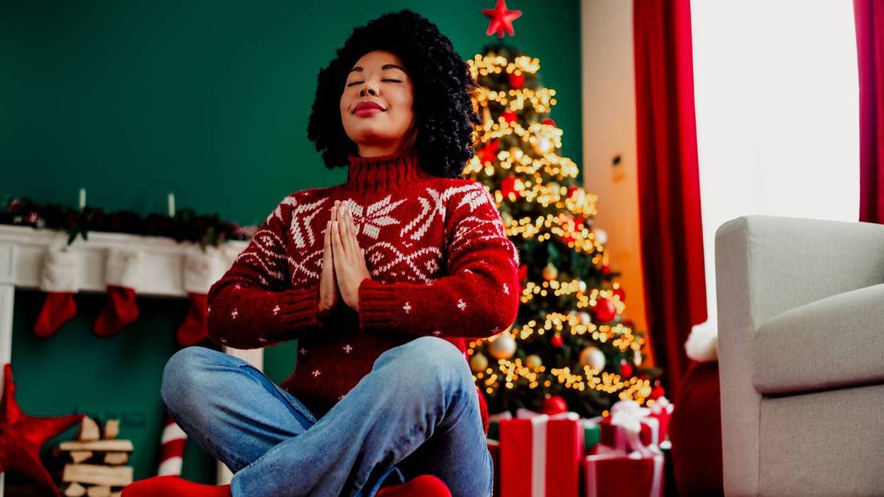 woman meditating in cozy Christmas decorated home