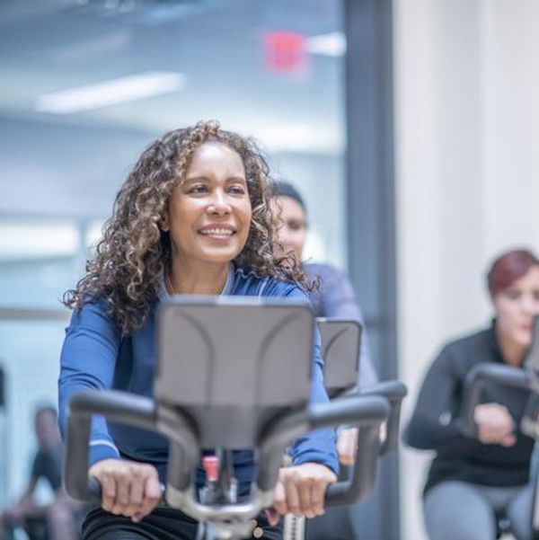 woman on an exercise bike at a group fitness class.