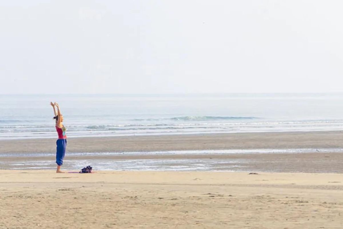 woman on beach doing yoga