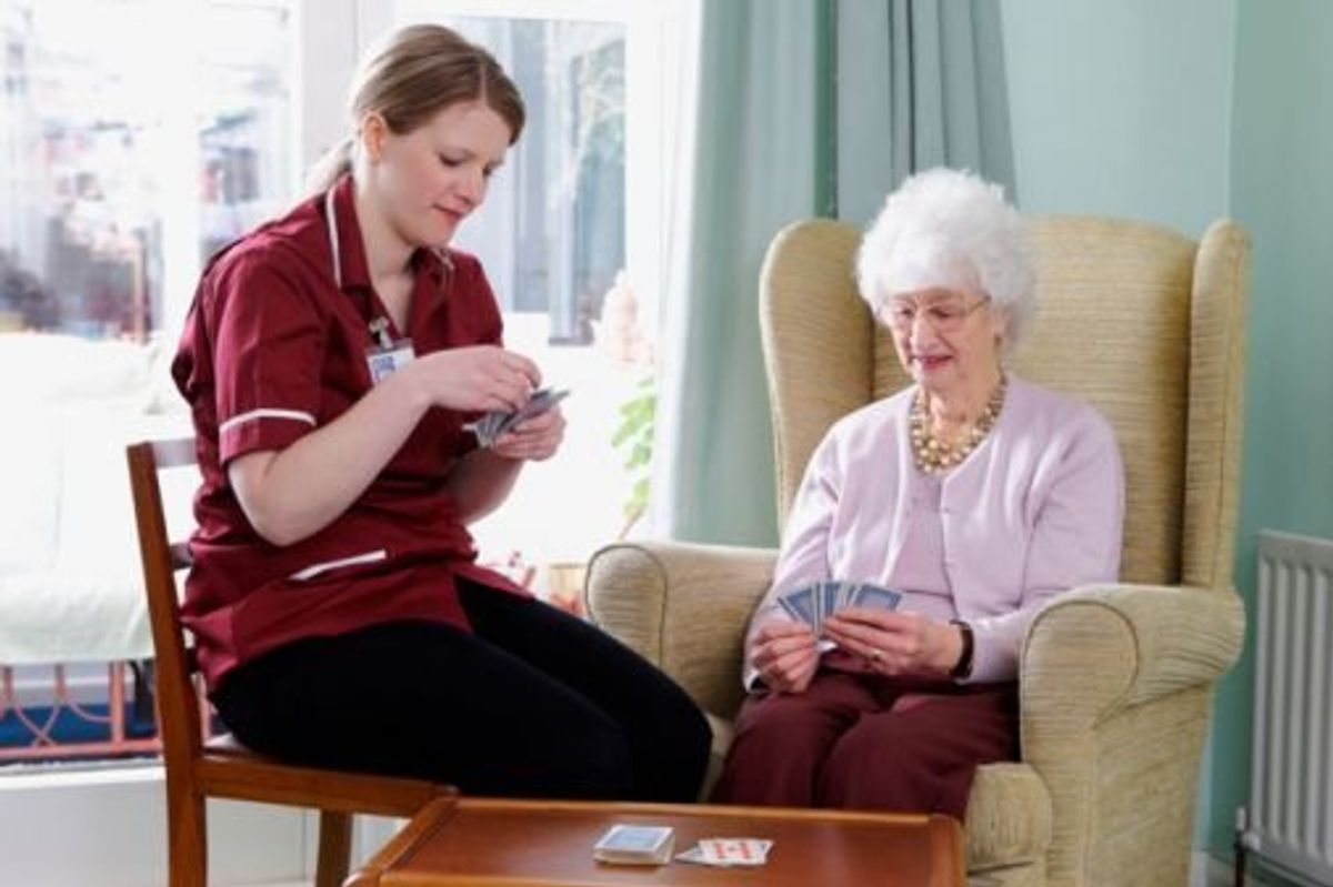 woman playing cards with elderly woman in a nursing home