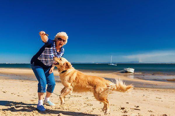 woman playing with her dog on a beach
