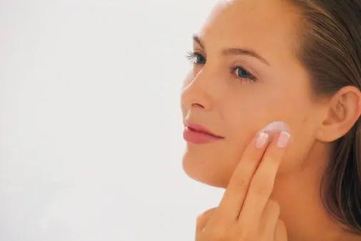 woman putting on face cream