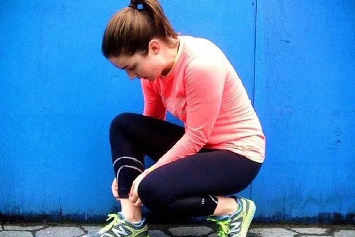 woman putting on running shoes