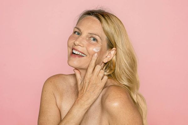 woman putting vaginal estrogen cream on her face