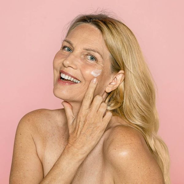 woman putting vaginal estrogen cream on her face
