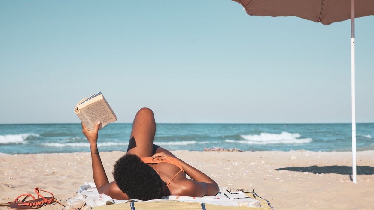 woman reading a book and relaxing on the beach