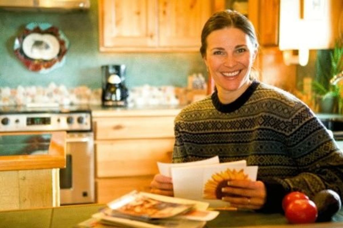 woman reading mail in her kitchen