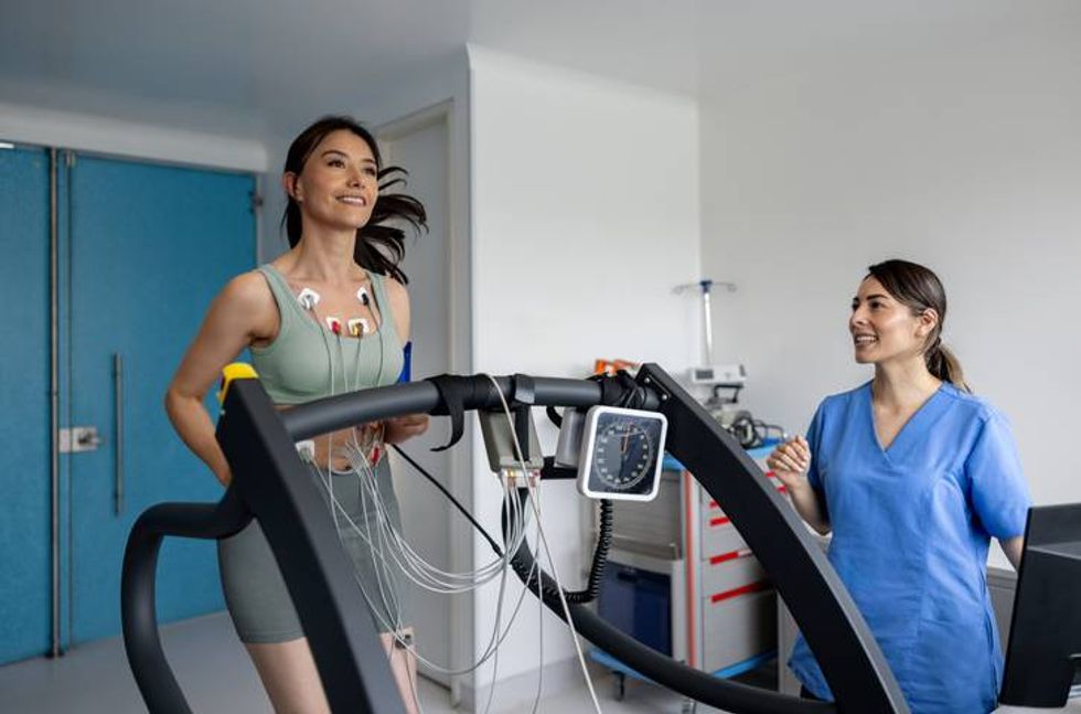 Woman running on a treadmill while doing a stress test