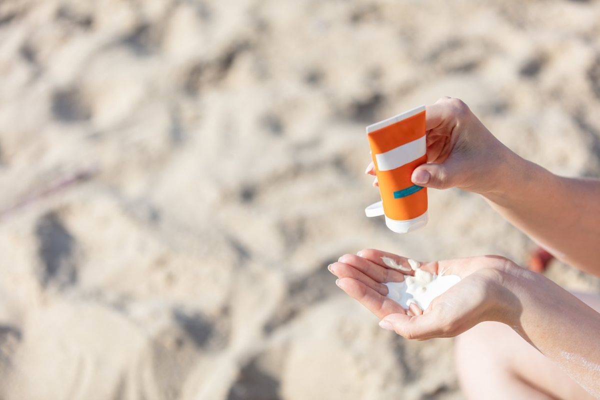 Woman's hand squirting sunscreen lotion
