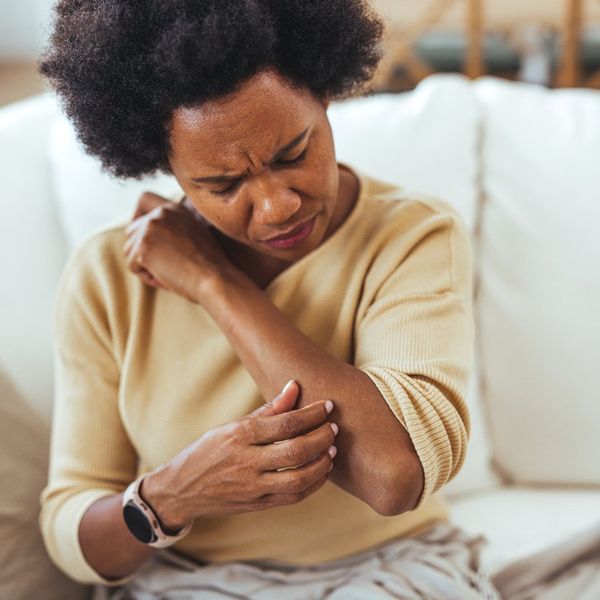 Woman Scratching Arm While Experiencing Skin Irritation