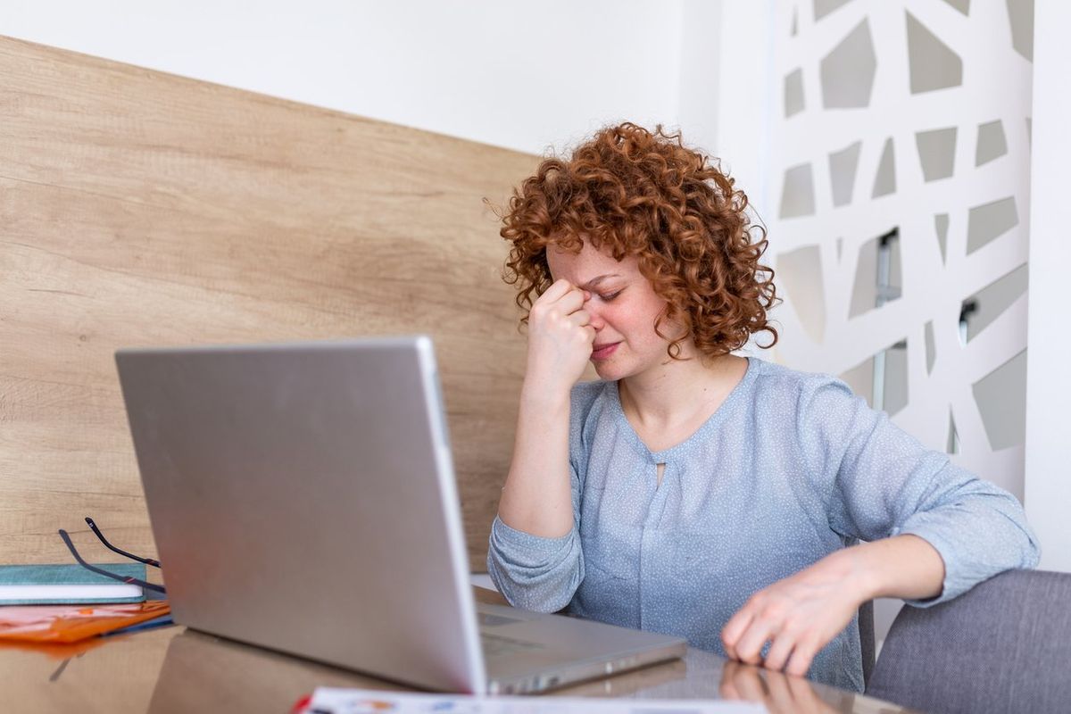 woman sitting in front of her computer suffering from dry eye