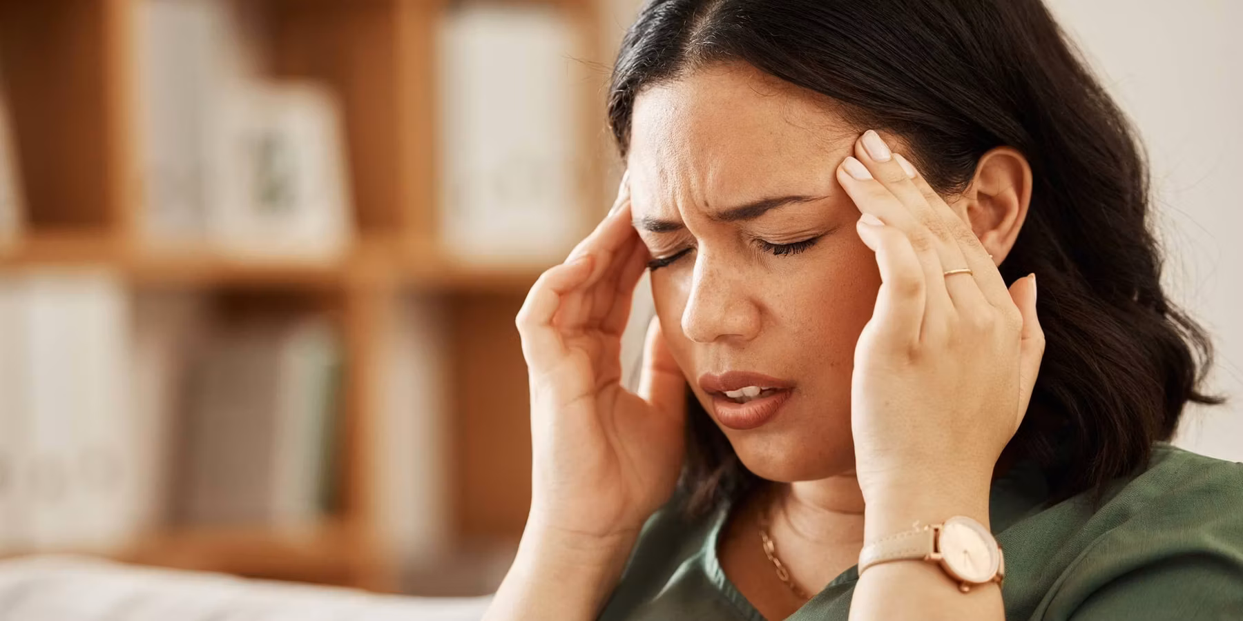 woman sitting on couch wtih a bad headache