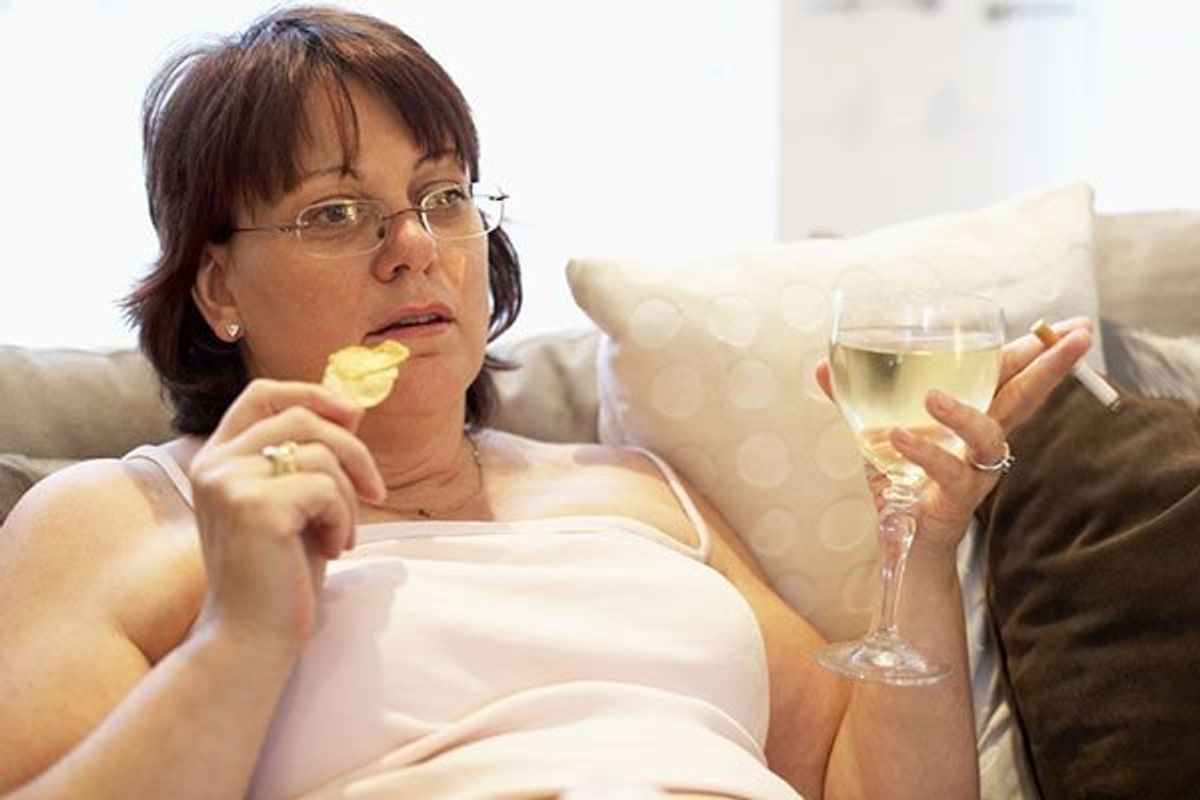 woman sitting on the couch smoking and drinking wine
