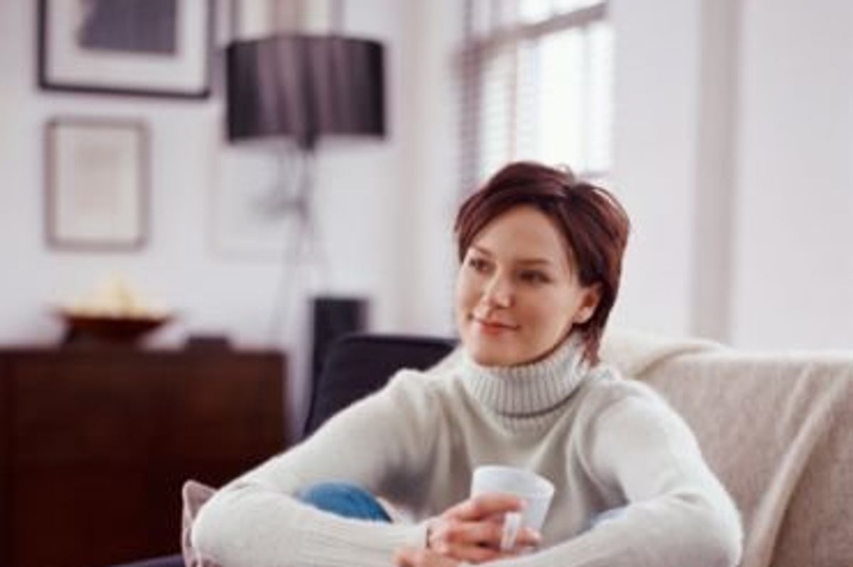woman sitting on the couch with a cup of coffee