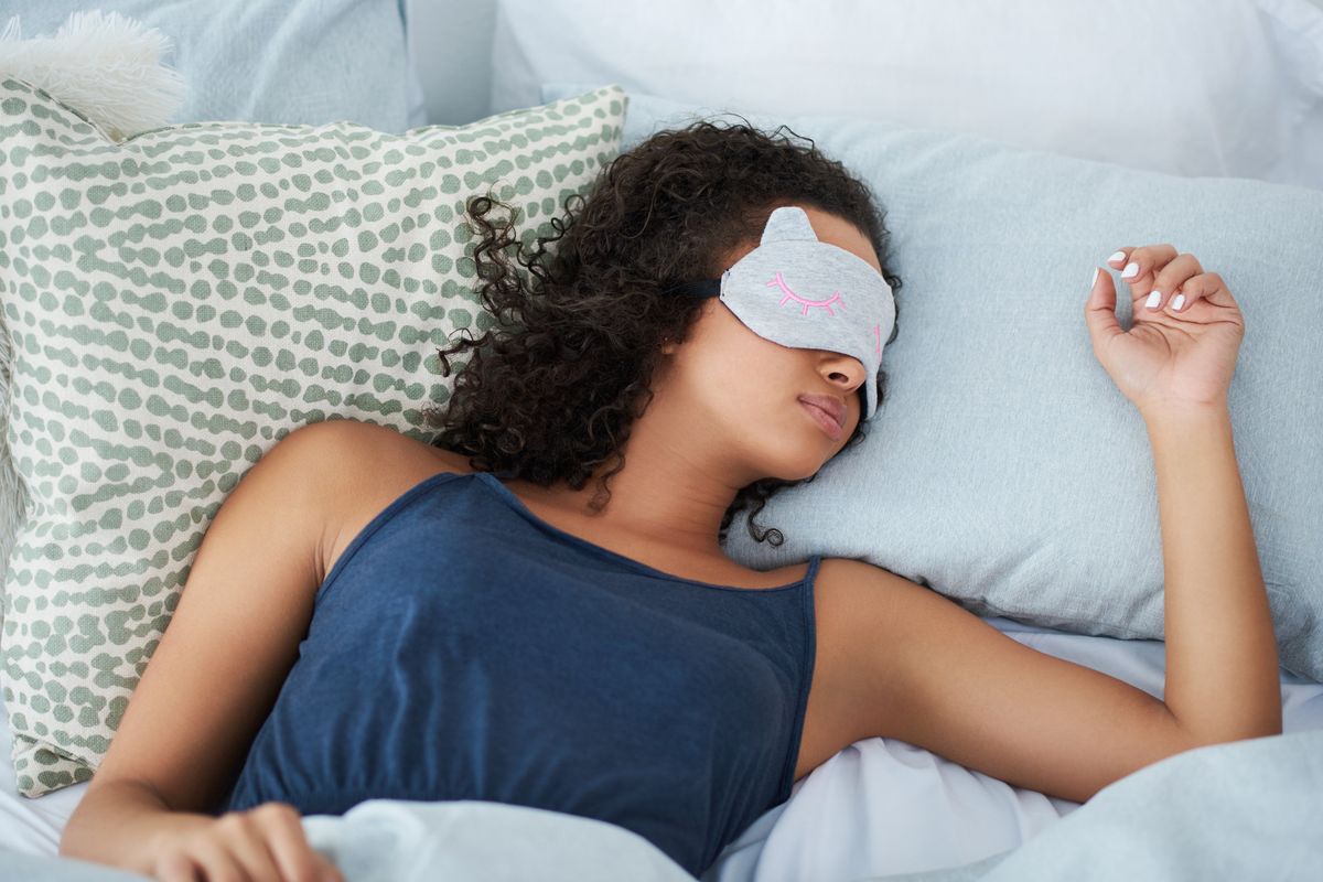 woman sleeping in bed with an eye mask during the morning