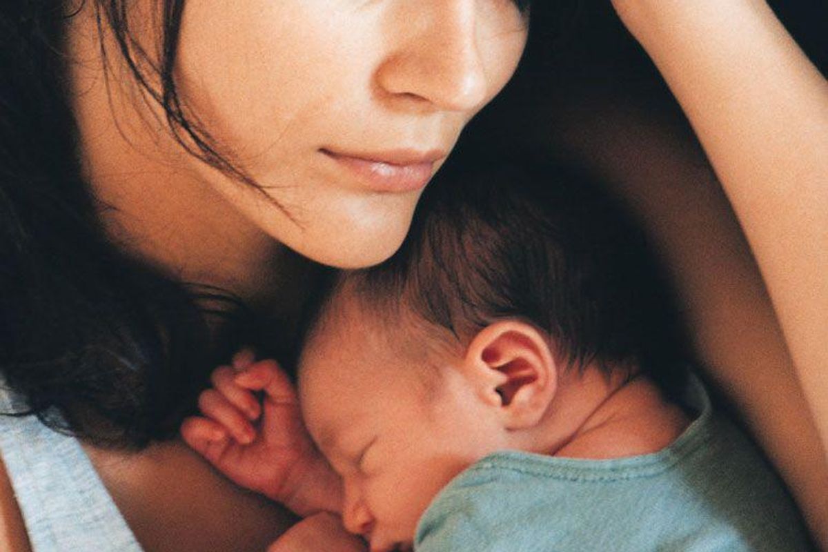 woman sleeping with infant on her chest