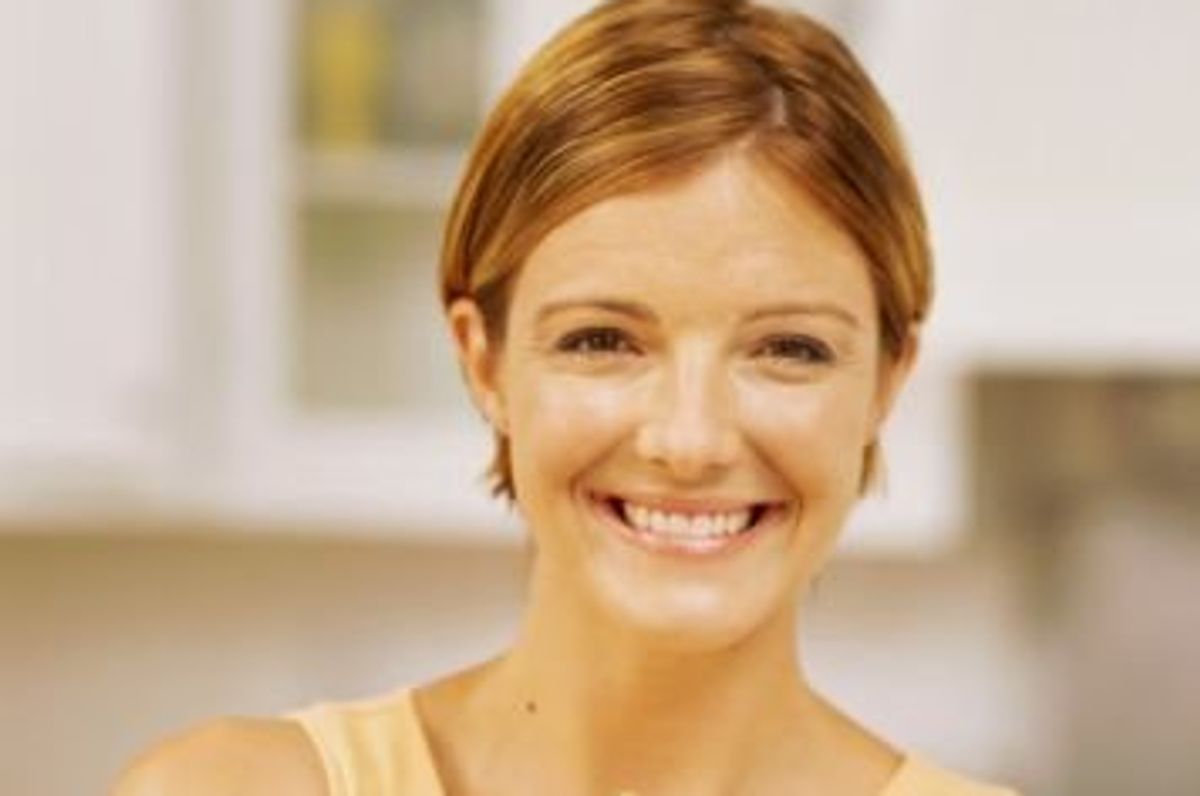 woman smiling holding a birthday cake