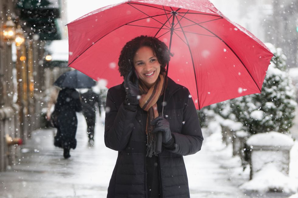 woman smiling talking on the phone in the snow