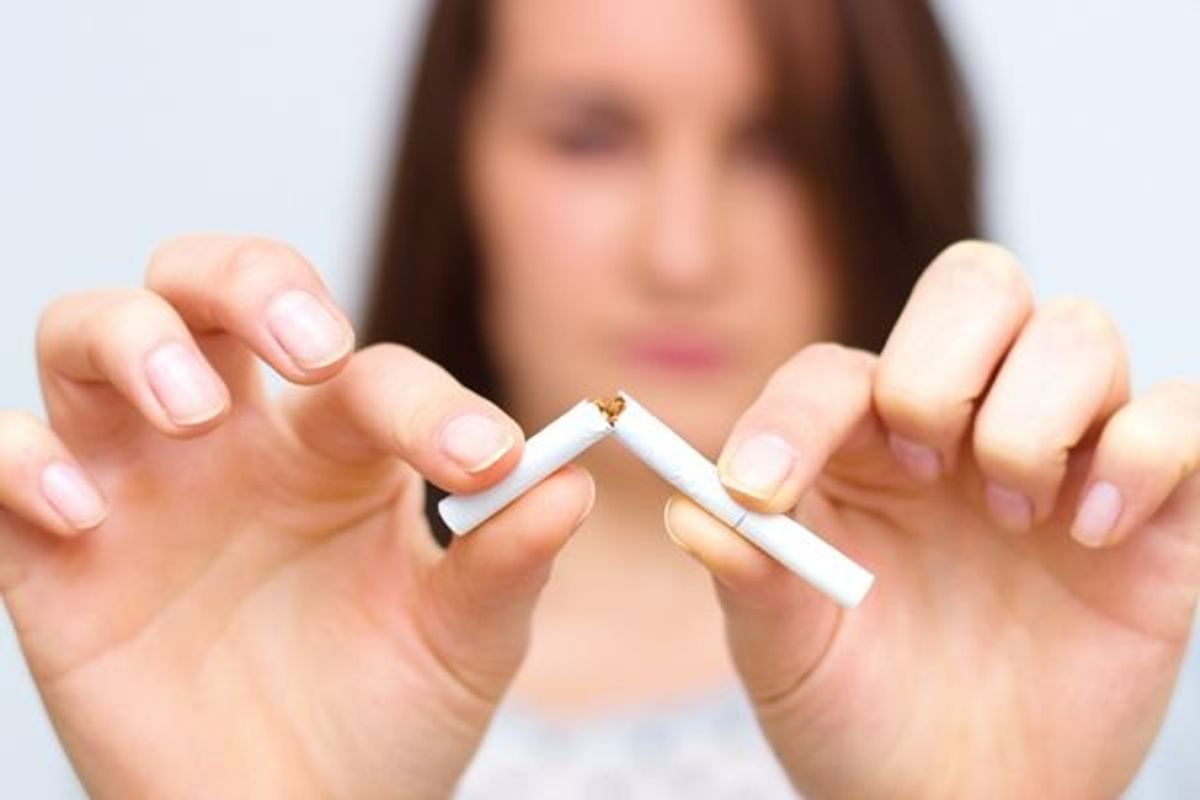 woman snapping a cigarette in half