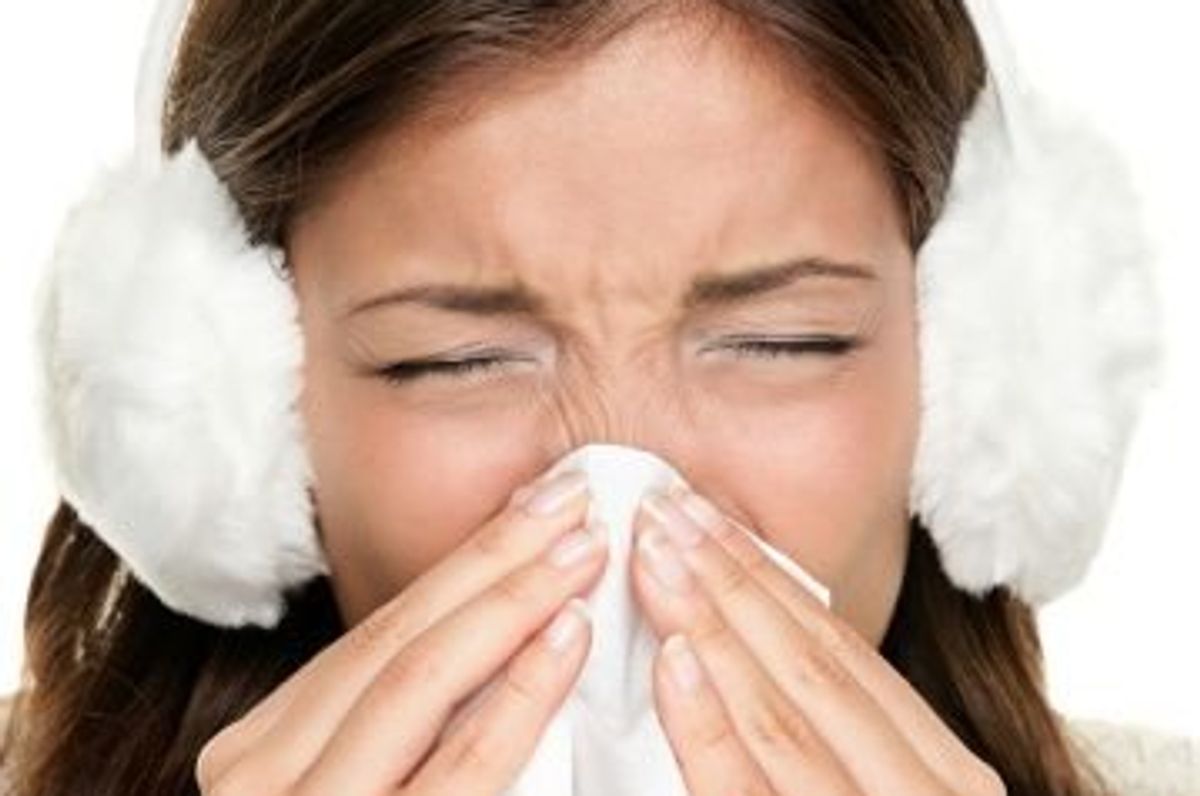 woman sneezing while wearing ear muffs