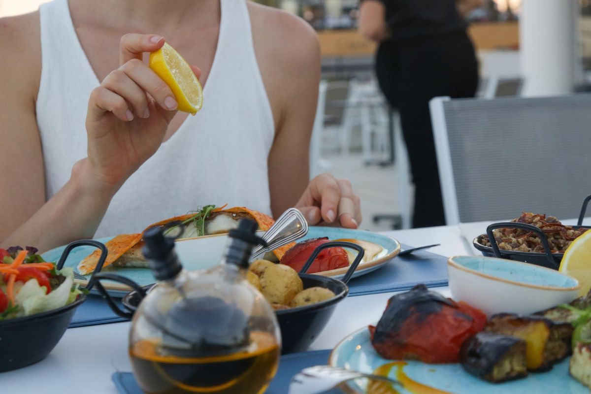 Woman squeezing lemon over a meal