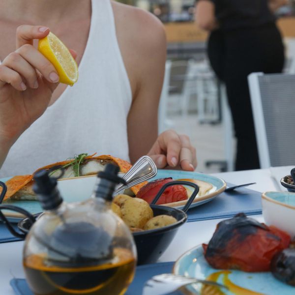 Woman squeezing lemon over a meal