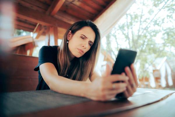 Woman Squinting Trying to Read Small Text on her Phone