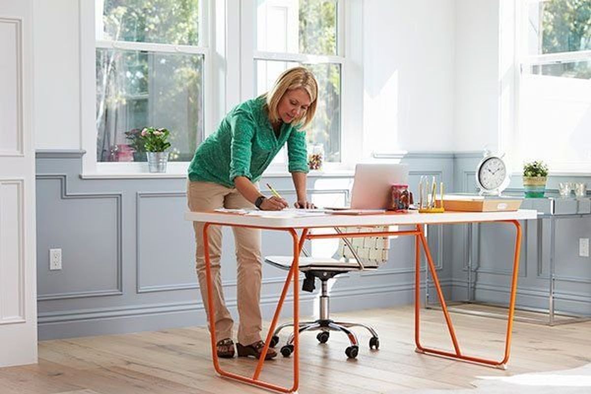 woman standing up at her home office working