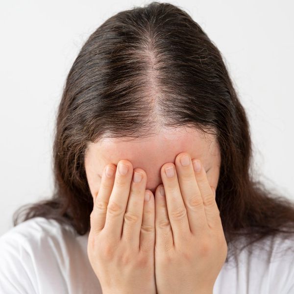 Woman stressed and crying over rapid hair loss