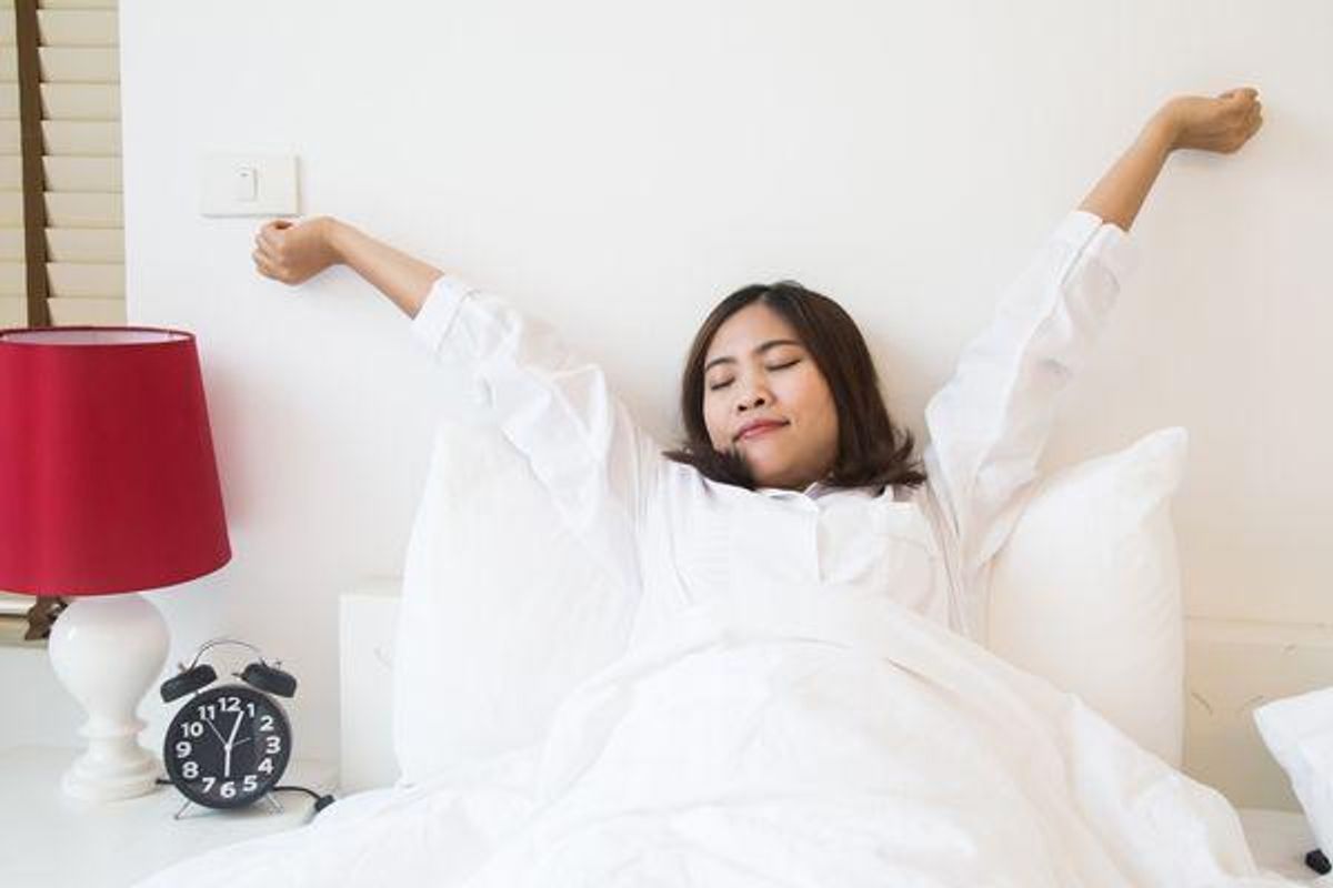 woman stretching in bed
