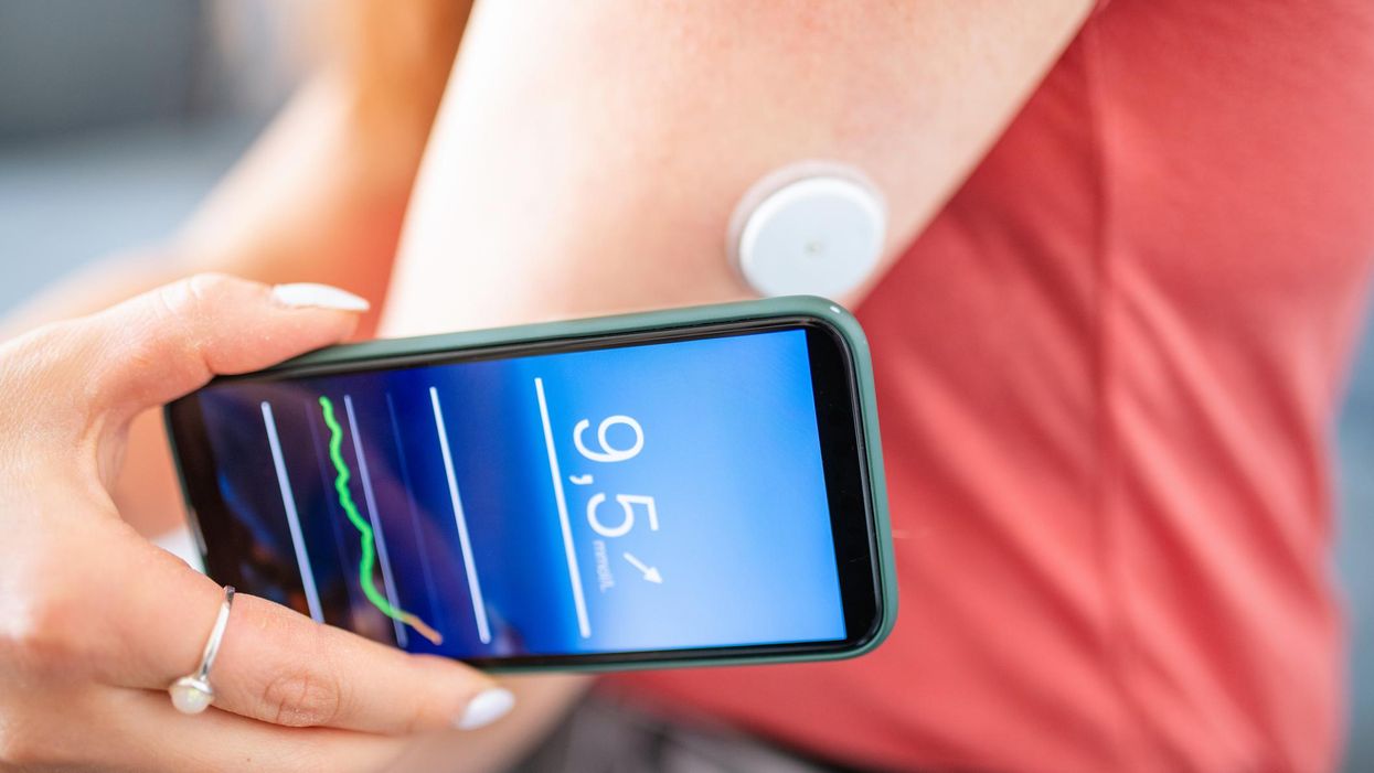 Woman Swiping Glucose Sensor with Phone for Measurement