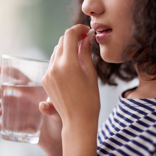 woman taking a pill with water