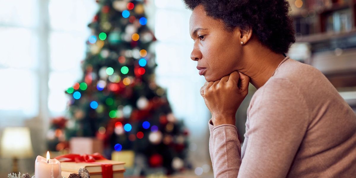 woman thinking of something while spending Christmas alone at home